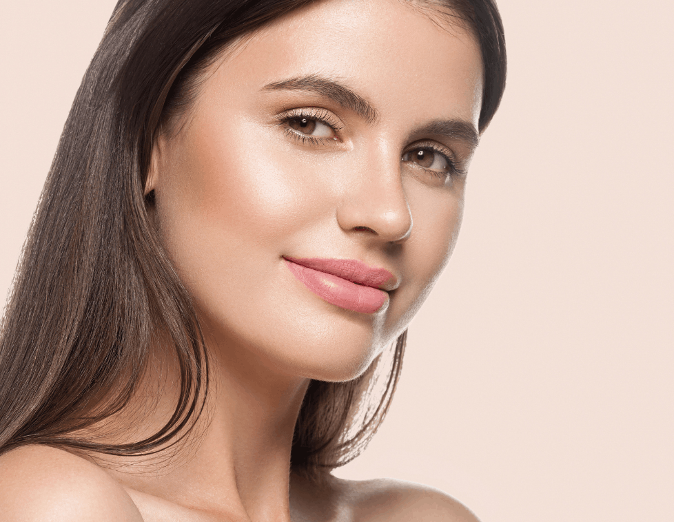 Close-up of a woman with glowing skin and natural makeup.