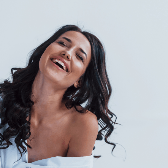 A joyful woman laughing with loose, flowing hair.
