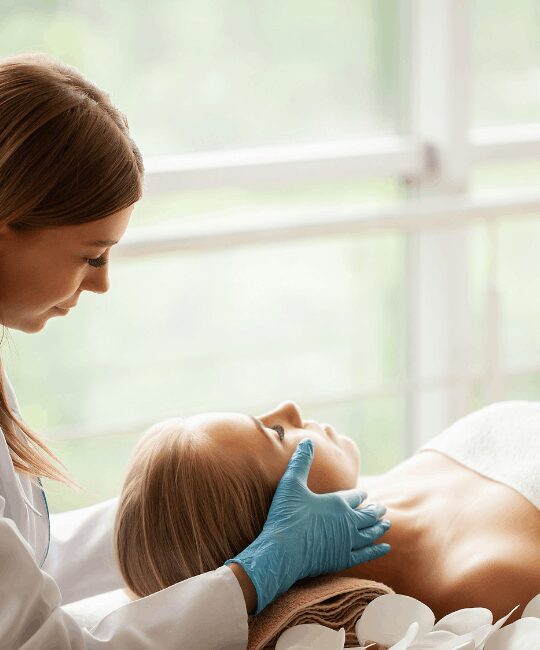 A professional performing a facial treatment on a relaxed client.