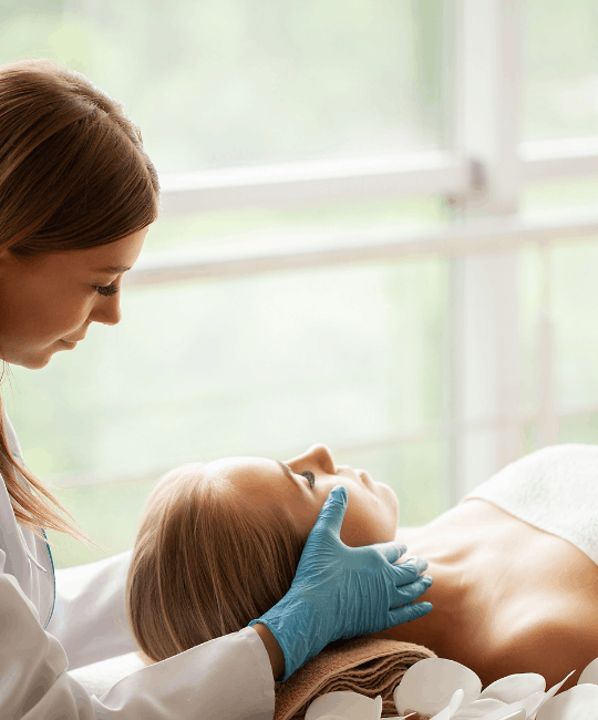 A professional performing a facial treatment on a relaxed client.