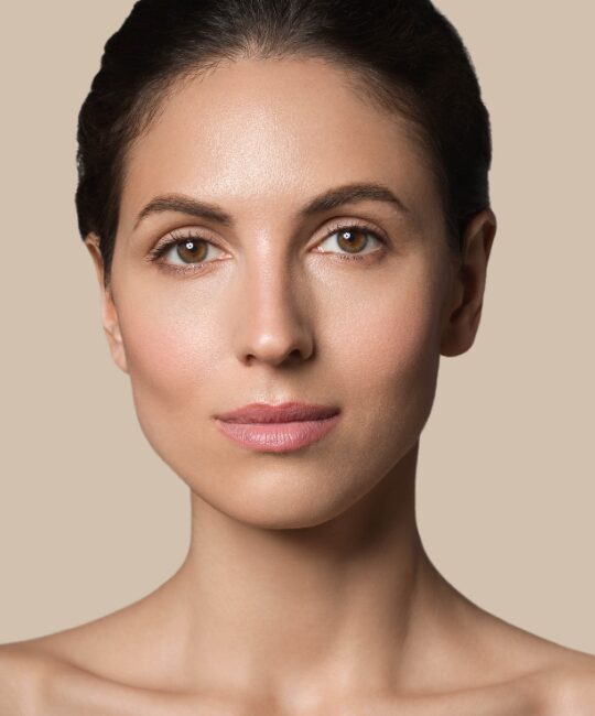 Close-up portrait of a woman with smooth skin and neutral expression.