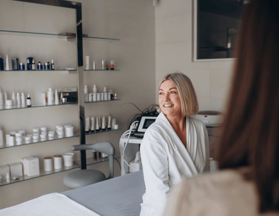 A woman in a spa robe smiling in a serene beauty salon.