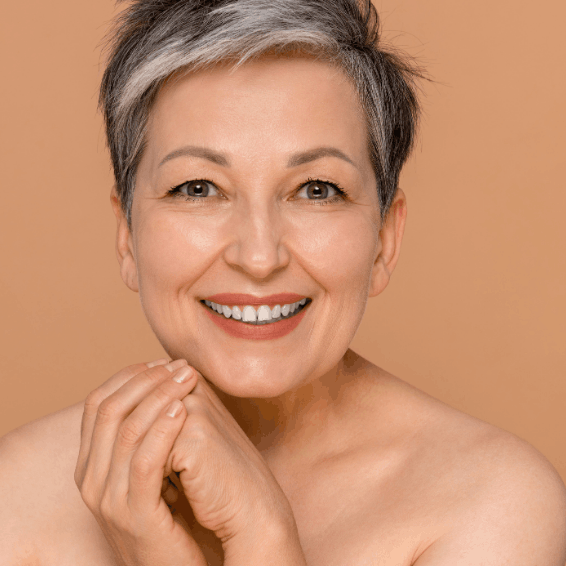 Smiling mature woman with short gray hair and flawless skin.