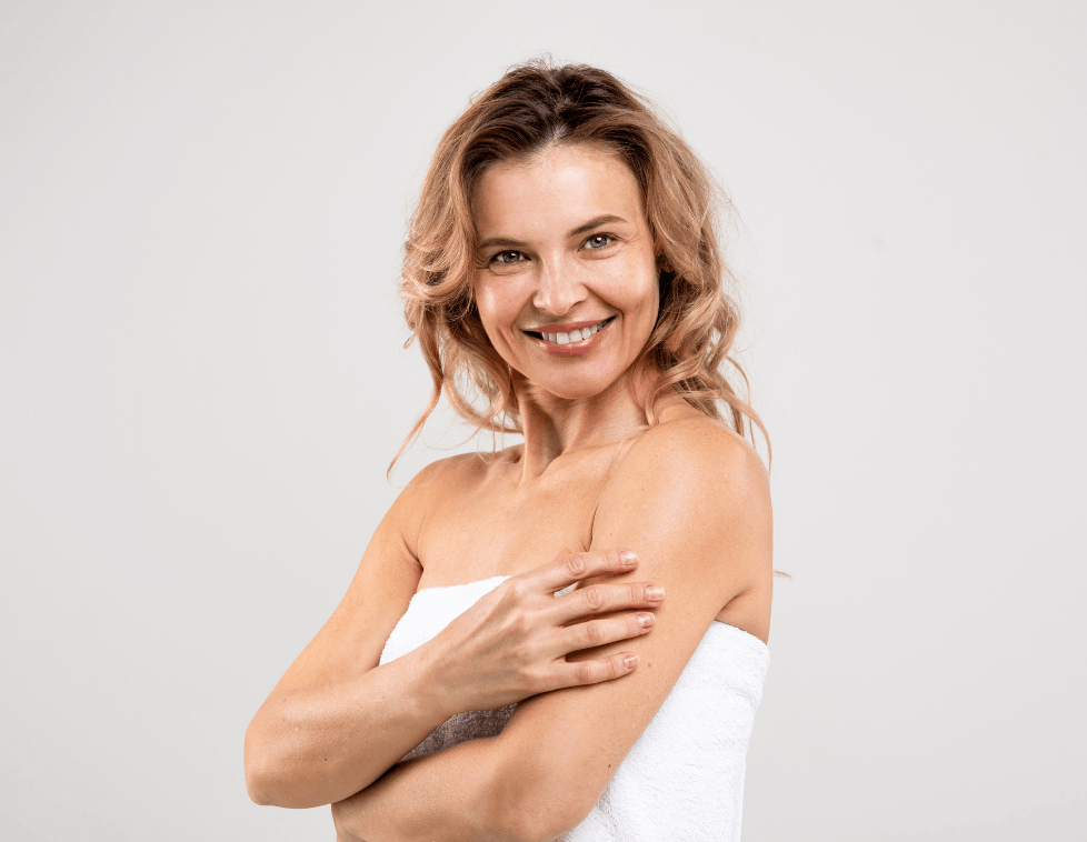 Smiling woman with wavy blonde hair and bare shoulders.