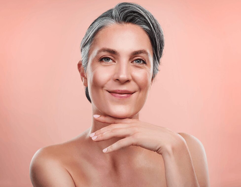 Confident mature woman with flawless skin and silver hair.