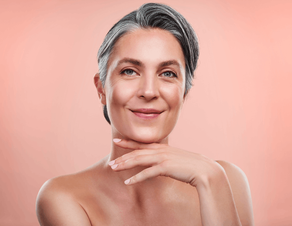 Confident mature woman with flawless skin and silver hair.