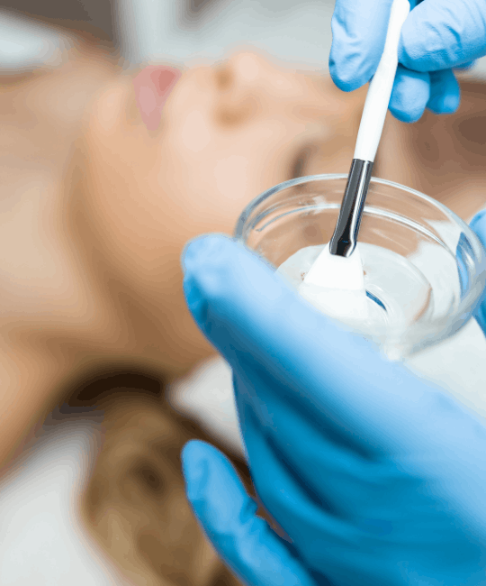 Close-up of a skincare specialist holding a brush with cream.