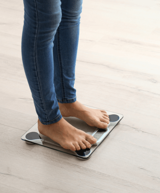Person standing barefoot on a digital bathroom scale.