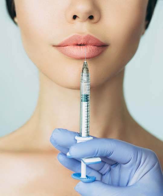 Close-up of lips with a syringe near them.