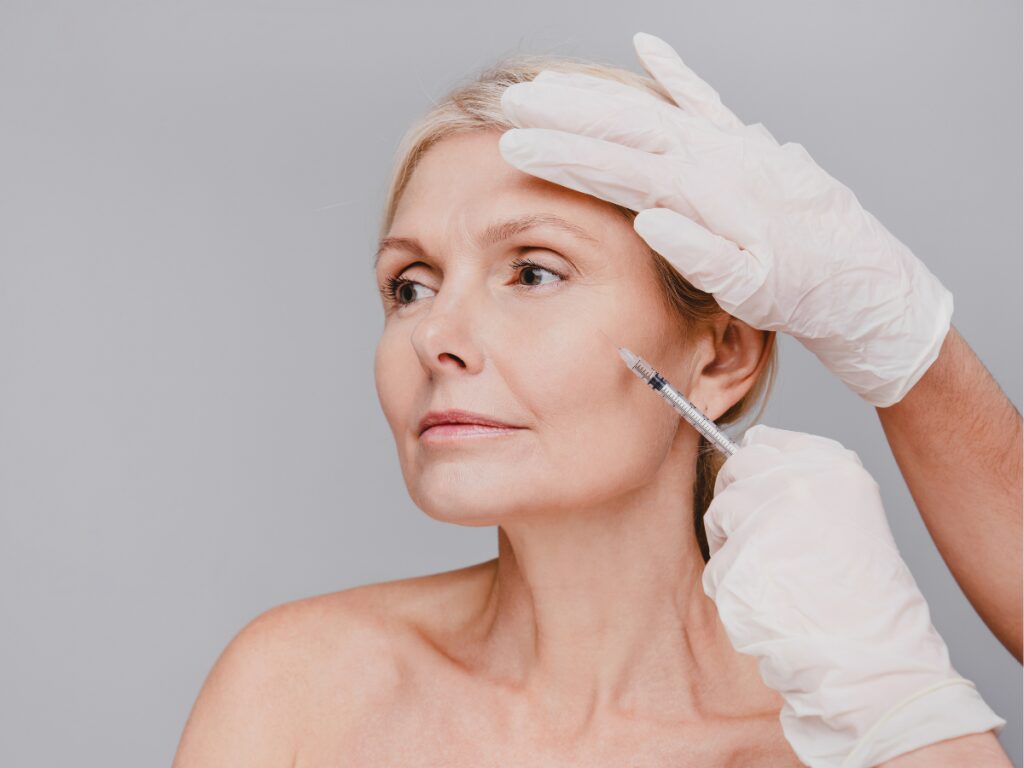 Woman receiving a cosmetic injection in her face.