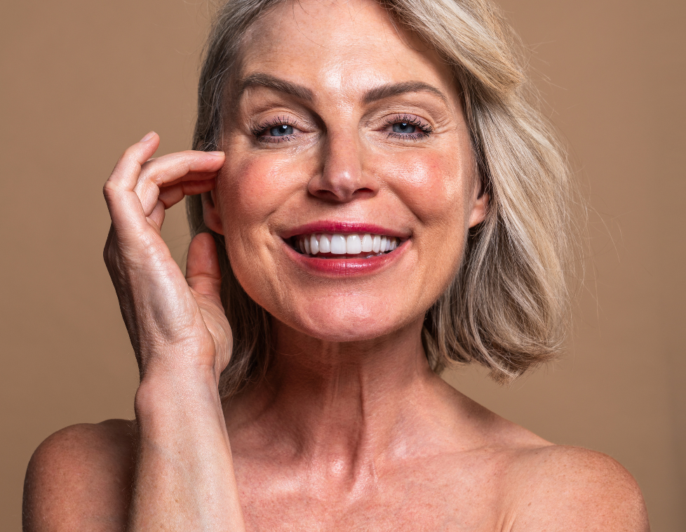 Smiling mature woman with clear skin and blonde hair.