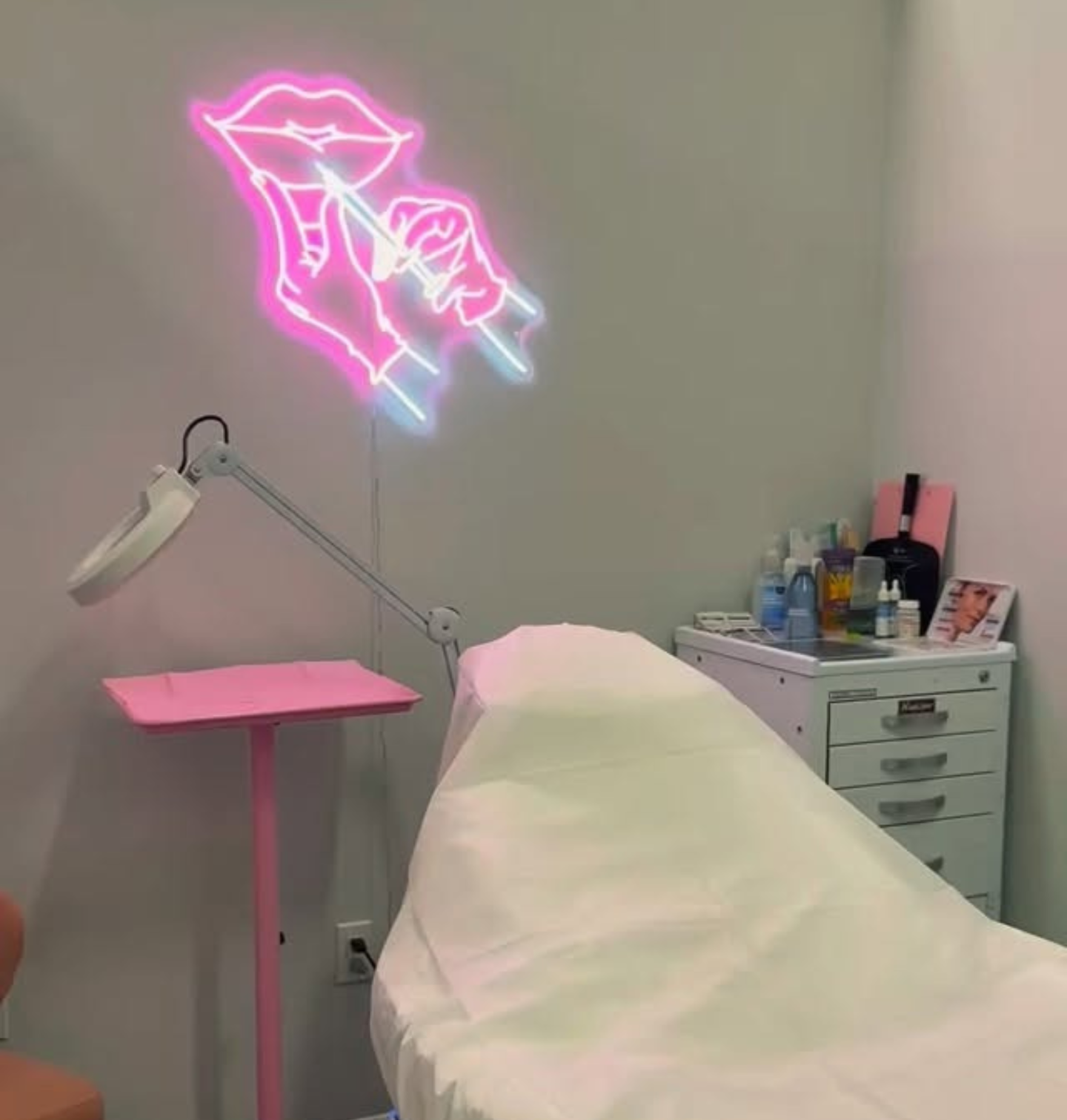 Cozy beauty treatment room with neon lips sign.